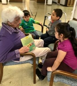 Elderly woman reading to children